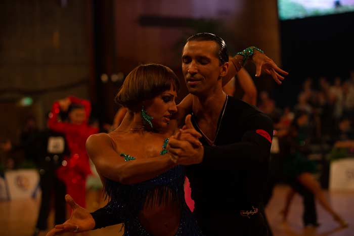 Standard Tanzpaar in einer Pose. Dame mit rotem Kleid